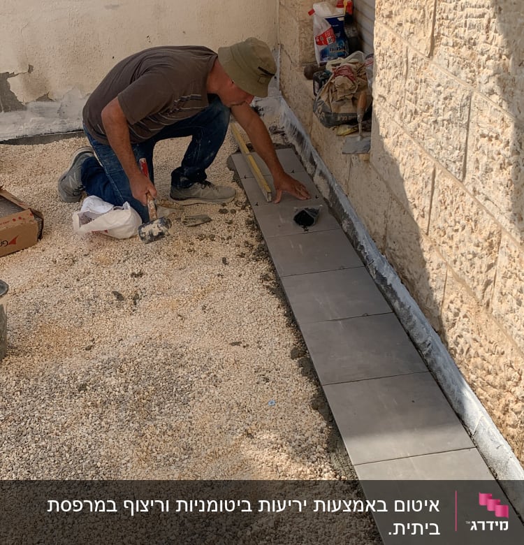 אדם עובד על איטום רצפה עם כלים וחומרים